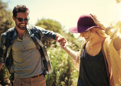 Happy couple holding hands in a field